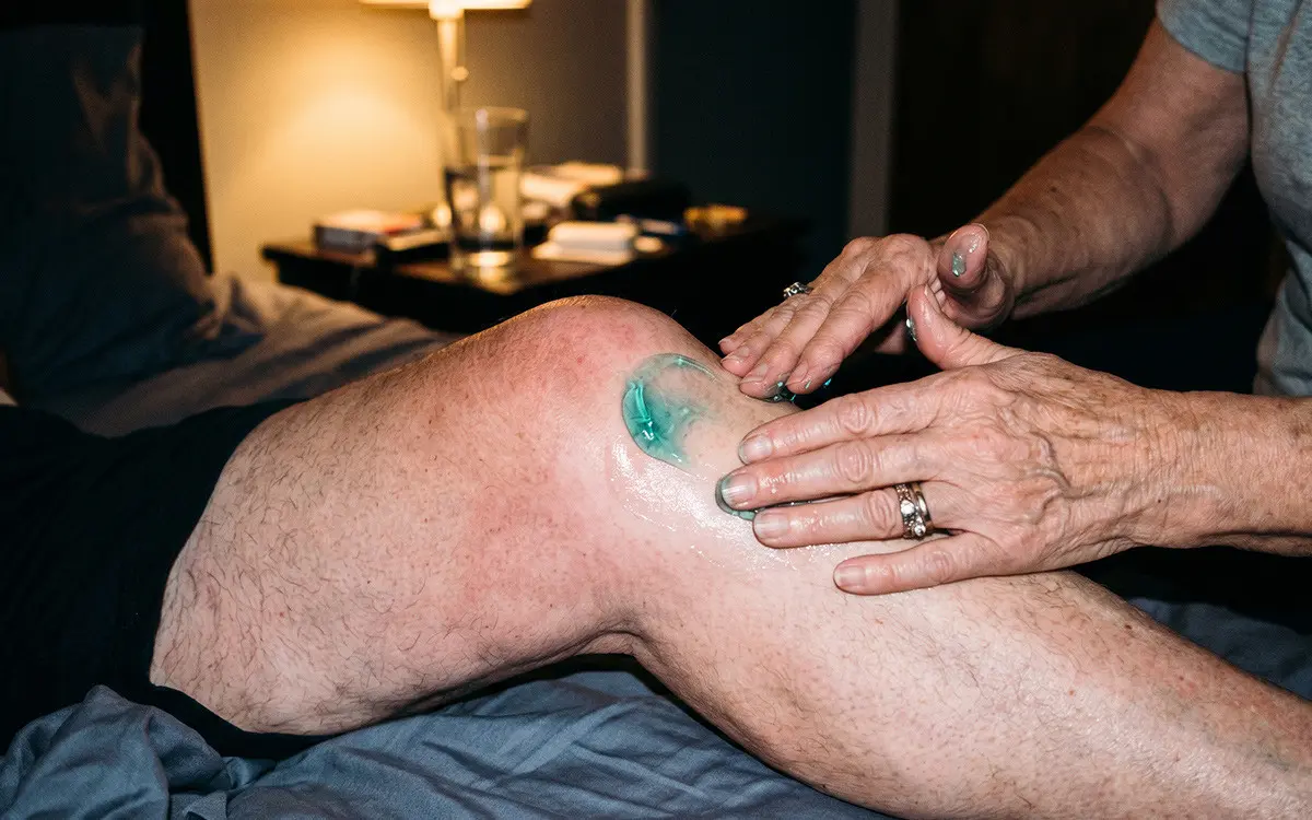 Wife showing her husband Kinzeno Triple-Action Massage Gel on her laptop